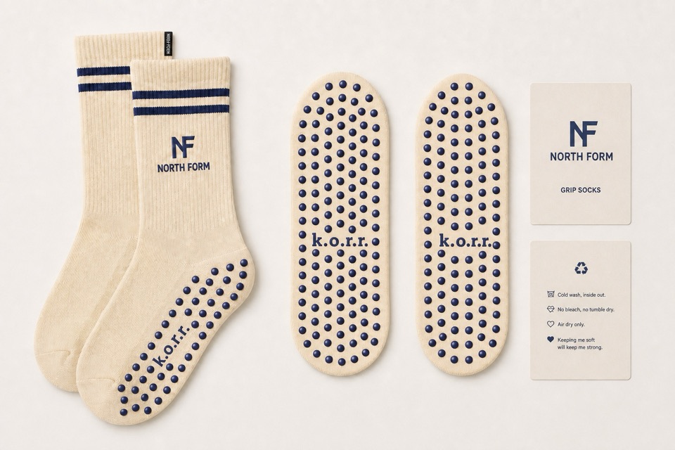 NORTH FORM cream and navy custom Pilates grip socks with branded soles and studio packaging